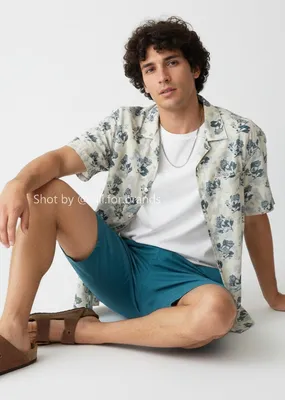 White Graphic Shirt and Blue Shorts men's wear lookbook image.