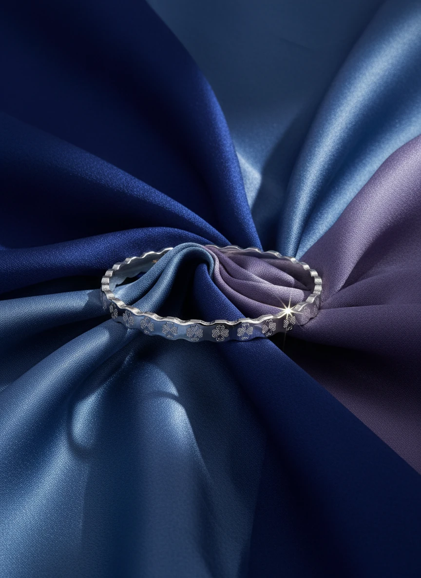 Studio AI photoshoot of an engraved silver bracelet on draped silk fabric, for a bracelet brand selling on marketplaces