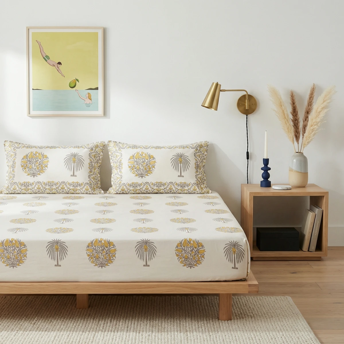 Kanika bed sheets featuring a floral and palm tree print in yellow and grey on an off-white cotton fabric.