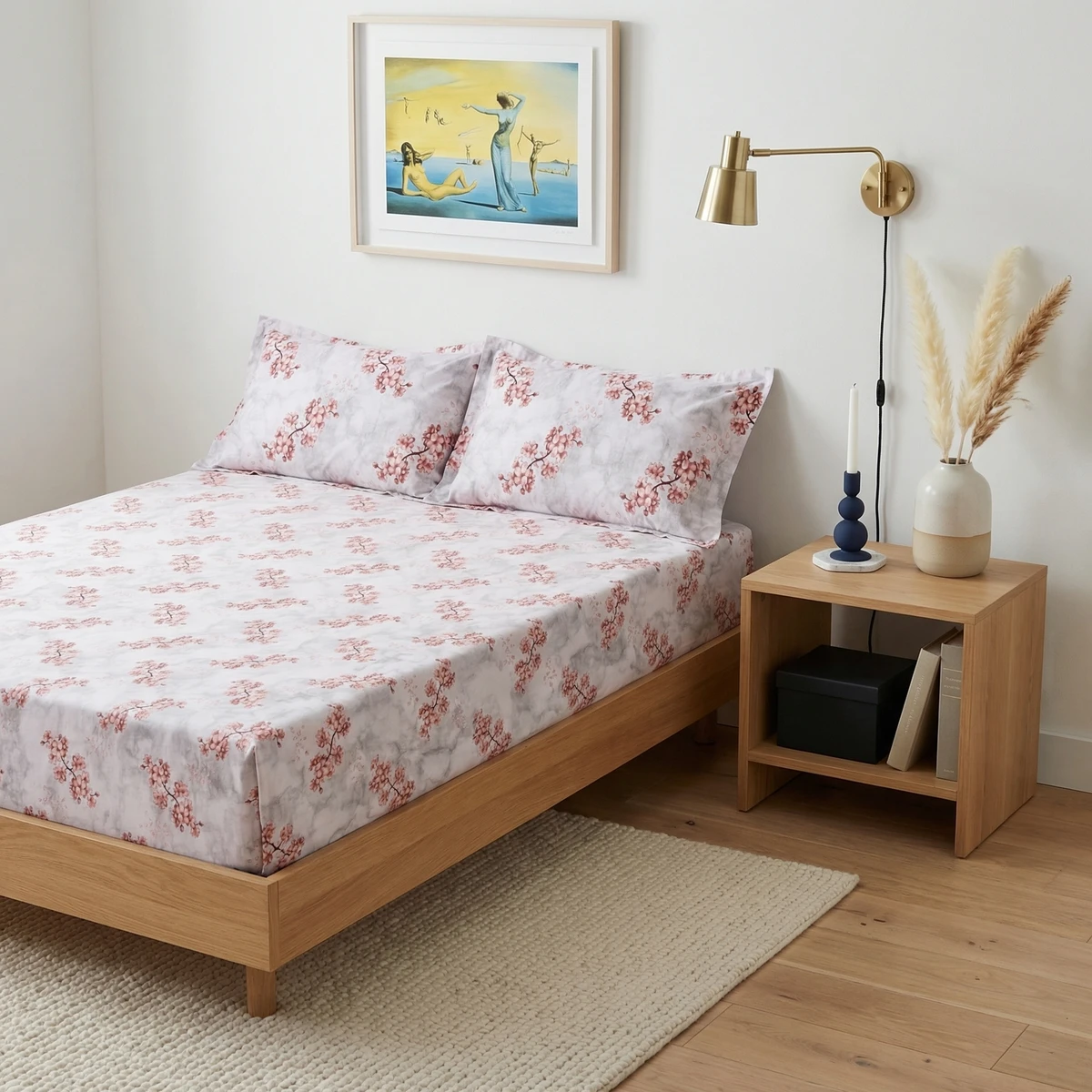 A bed dressed in Kanika bed sheets with pink floral print, featuring matching pillows in a modern bedroom.