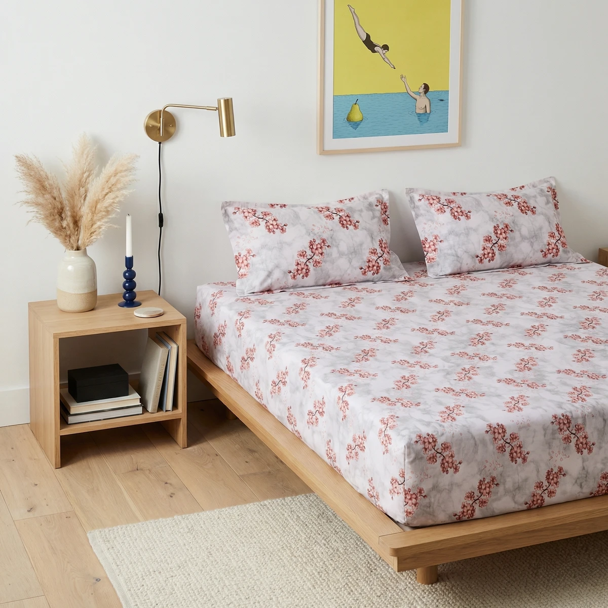 Voila bed sheets featuring a soft pink cherry blossom print on a light grey marble background in a modern bedroom.
