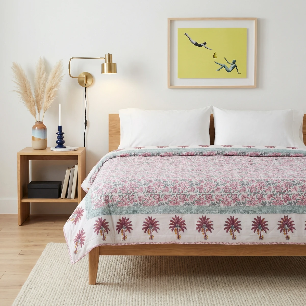 Kanika comforter with pink floral and palm tree block print on a wooden bed in a modern bedroom.