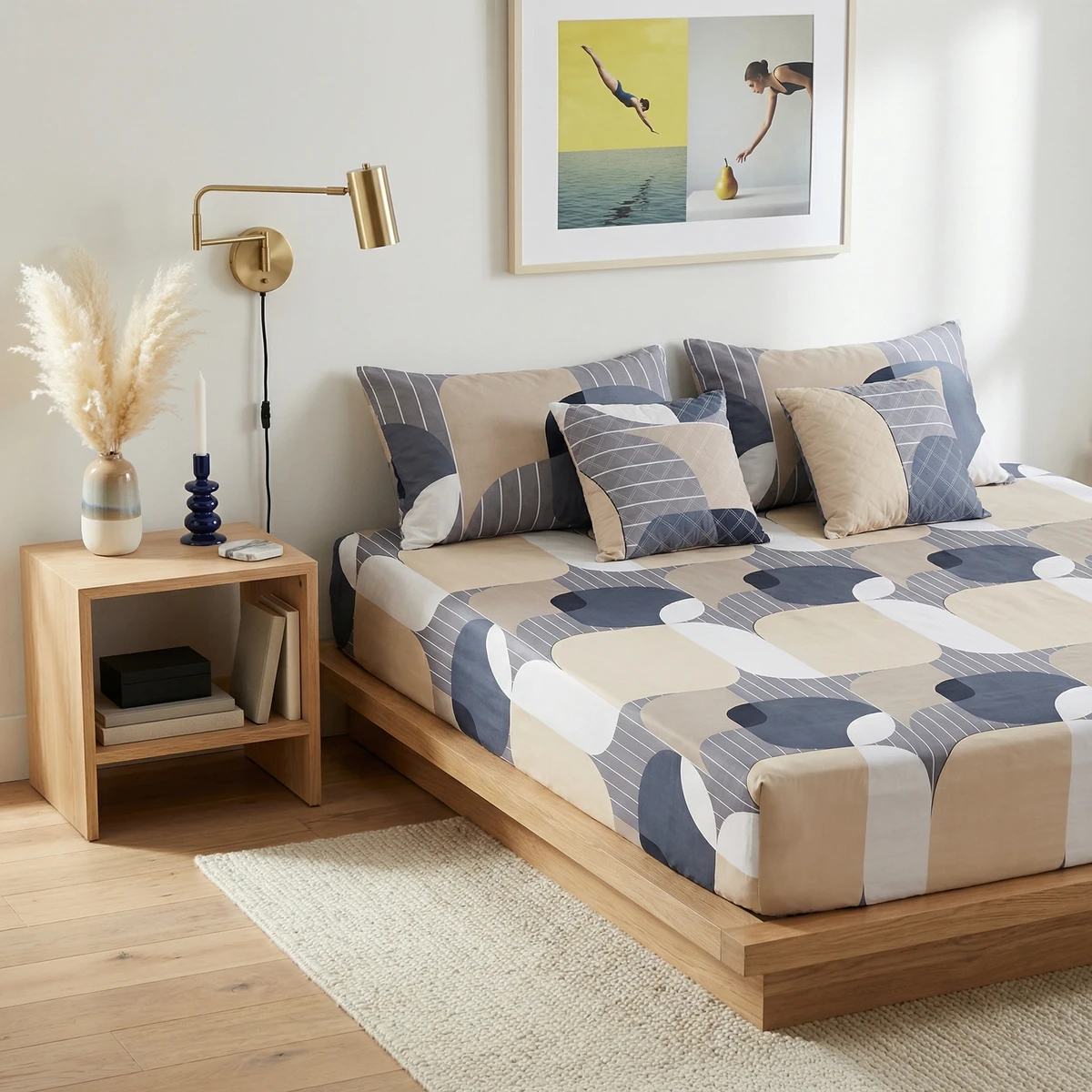 Kanika bed sheets featuring a geometric abstract pattern in blue, beige, and white on a wooden platform bed.