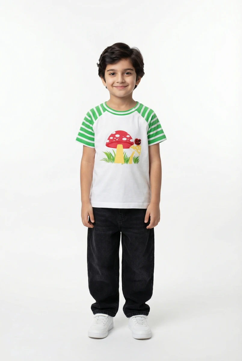 Young boy wearing a white t-shirt with green striped raglan sleeves and a mushroom graphic, paired with black pants.