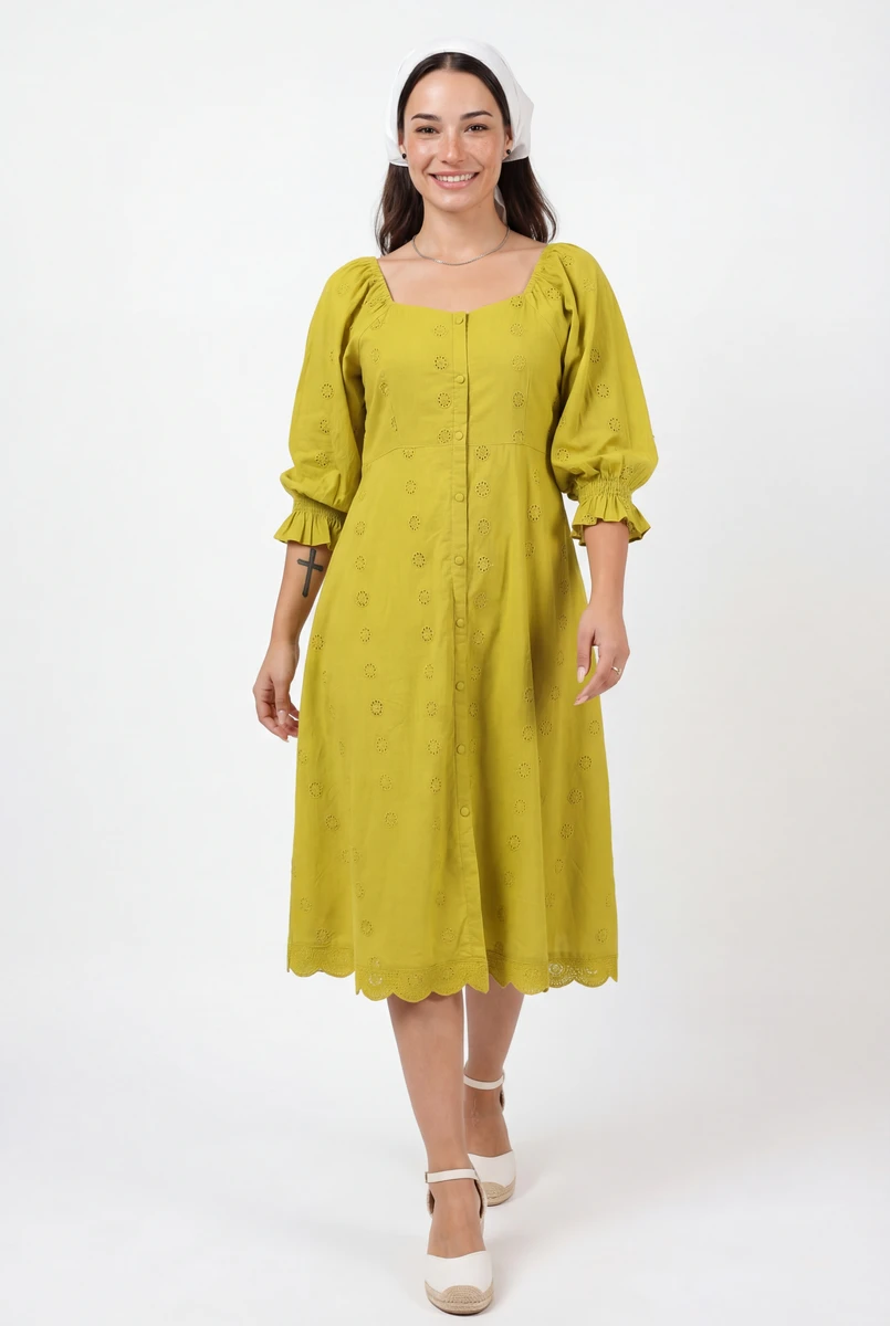 Model wearing a yellow midi dress with eyelet embroidery, puff sleeves, and a front button placket against a white background.