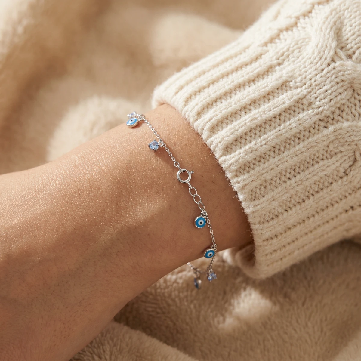 Studio AI photoshoot on a model of a silver chain bracelet with charms, for a bracelet brand selling on marketplaces