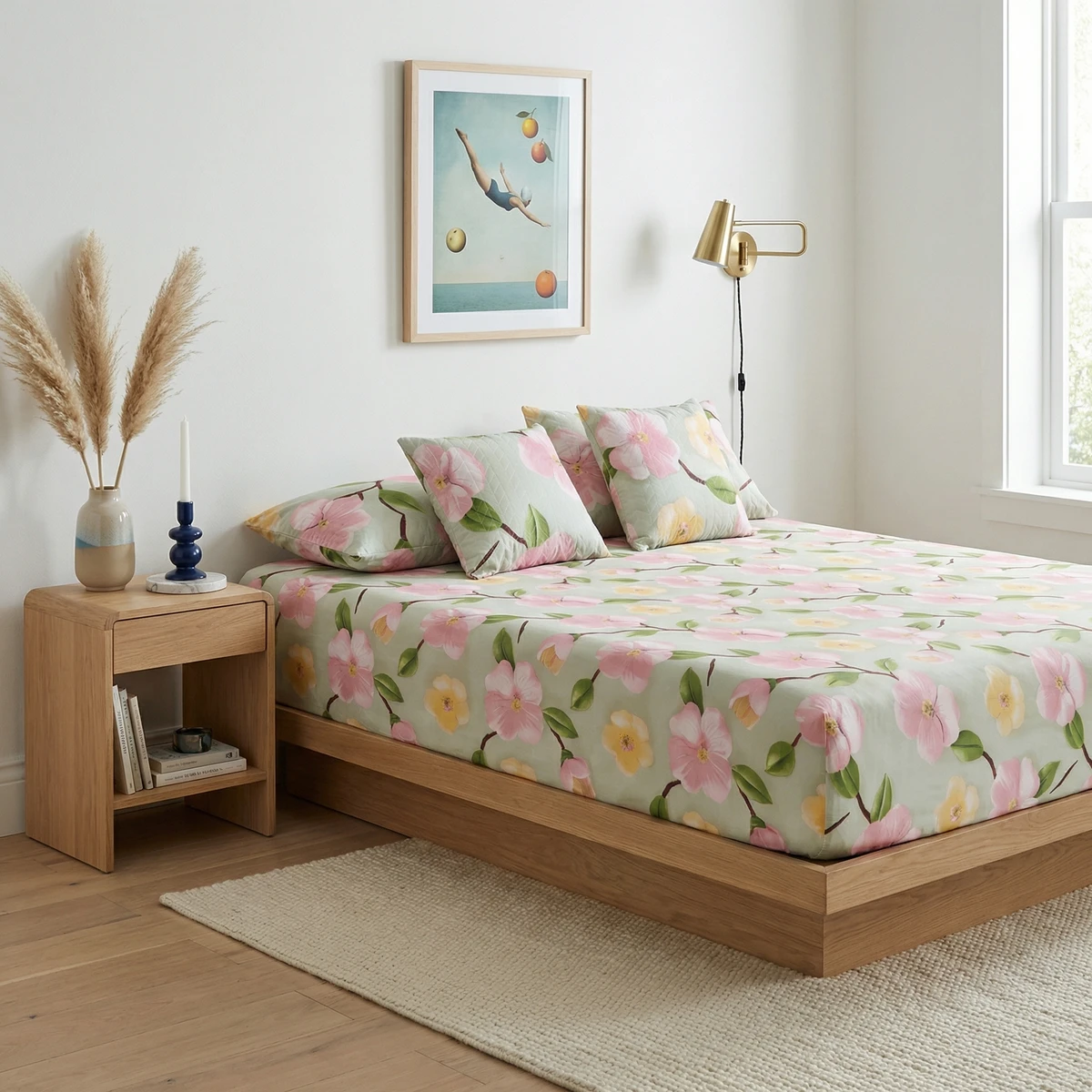 Kanika bed featuring light green bed sheets with a vibrant pink and yellow floral print in a bright bedroom.