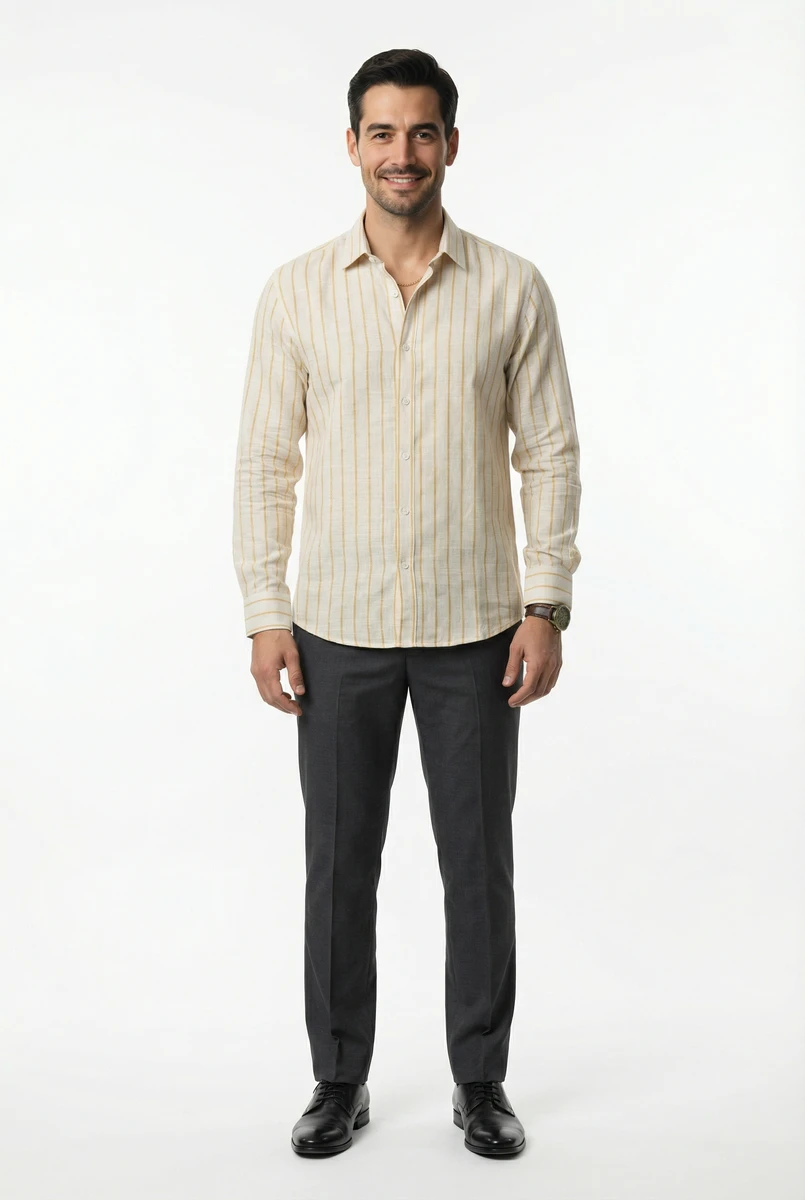 Man standing in a cream-striped long-sleeve shirt and dark trousers against a plain white studio backdrop.