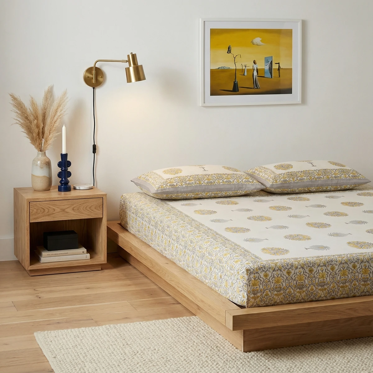 Bed sheets with yellow and grey floral block print on a wooden platform bed in a modern bedroom setting.
