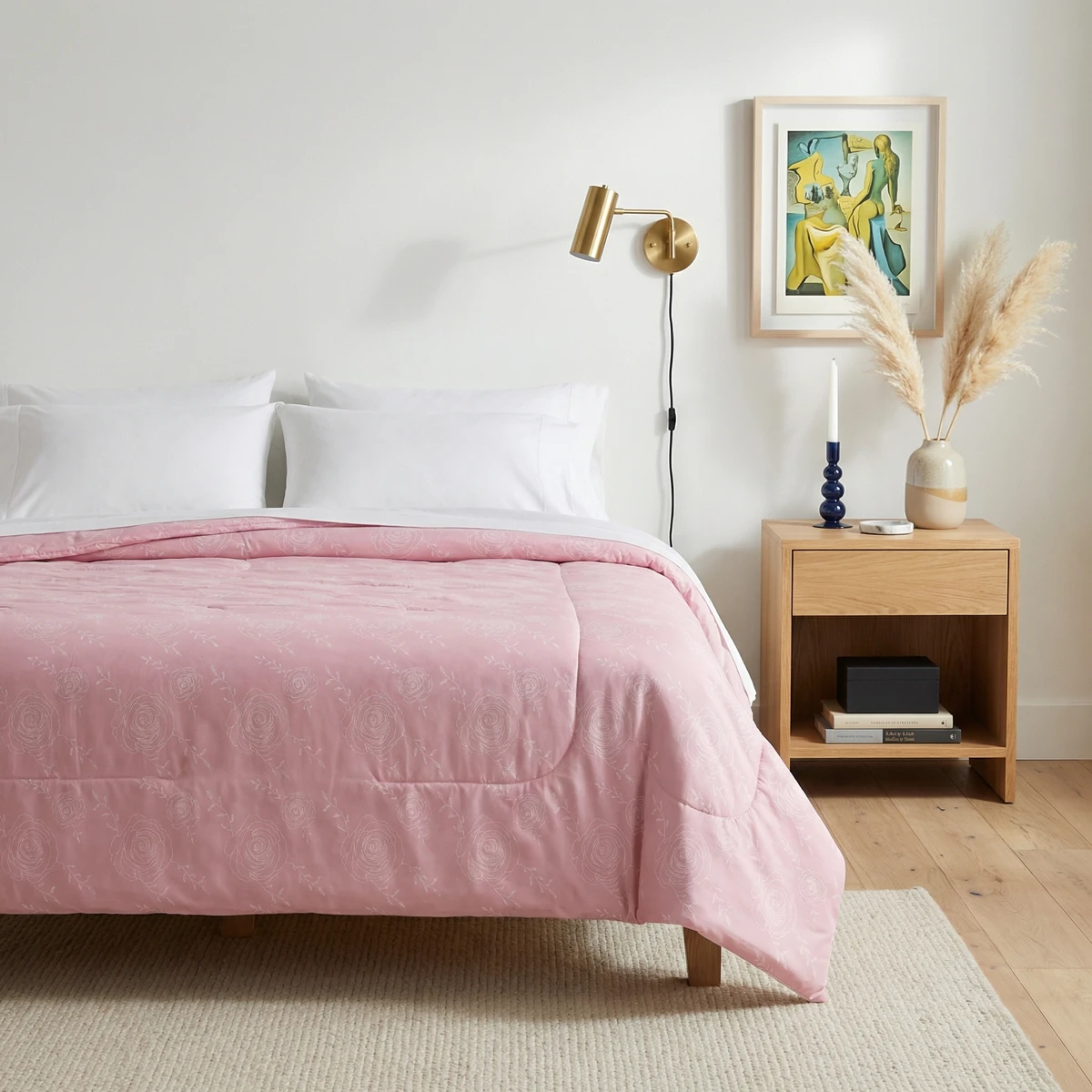Kanika comforter in soft pink with white rose line art patterns, styled on a wooden bed frame in a minimalist bedroom.