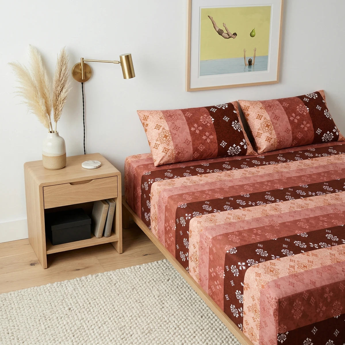 Voila bed sheets featuring a striped pattern in shades of red, pink, and brown with intricate white motifs in a modern bedroom.