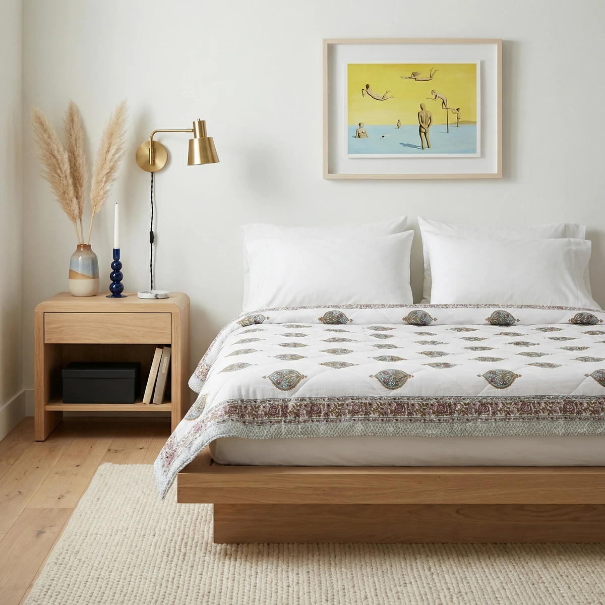 Kanika comforter with a white and patterned design on a wooden bed in a neutral bedroom setting.
