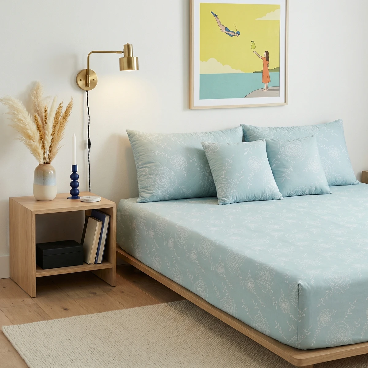 Kanika bed dressed in light blue floral pattern bed sheets with matching pillows in a bright bedroom.