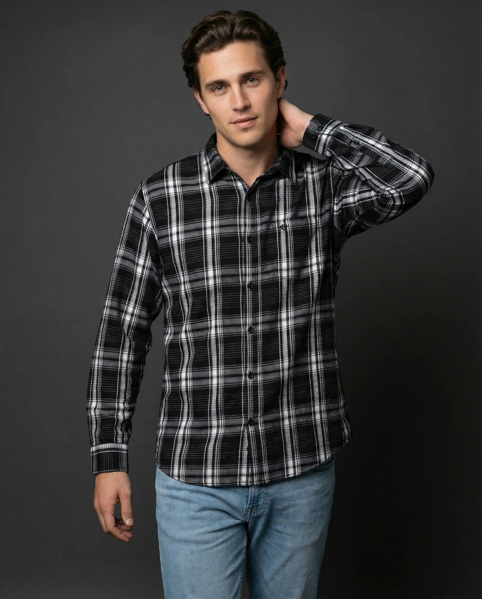 Man wearing a black and white plaid long sleeve button-up shirt and blue jeans against a dark grey background.