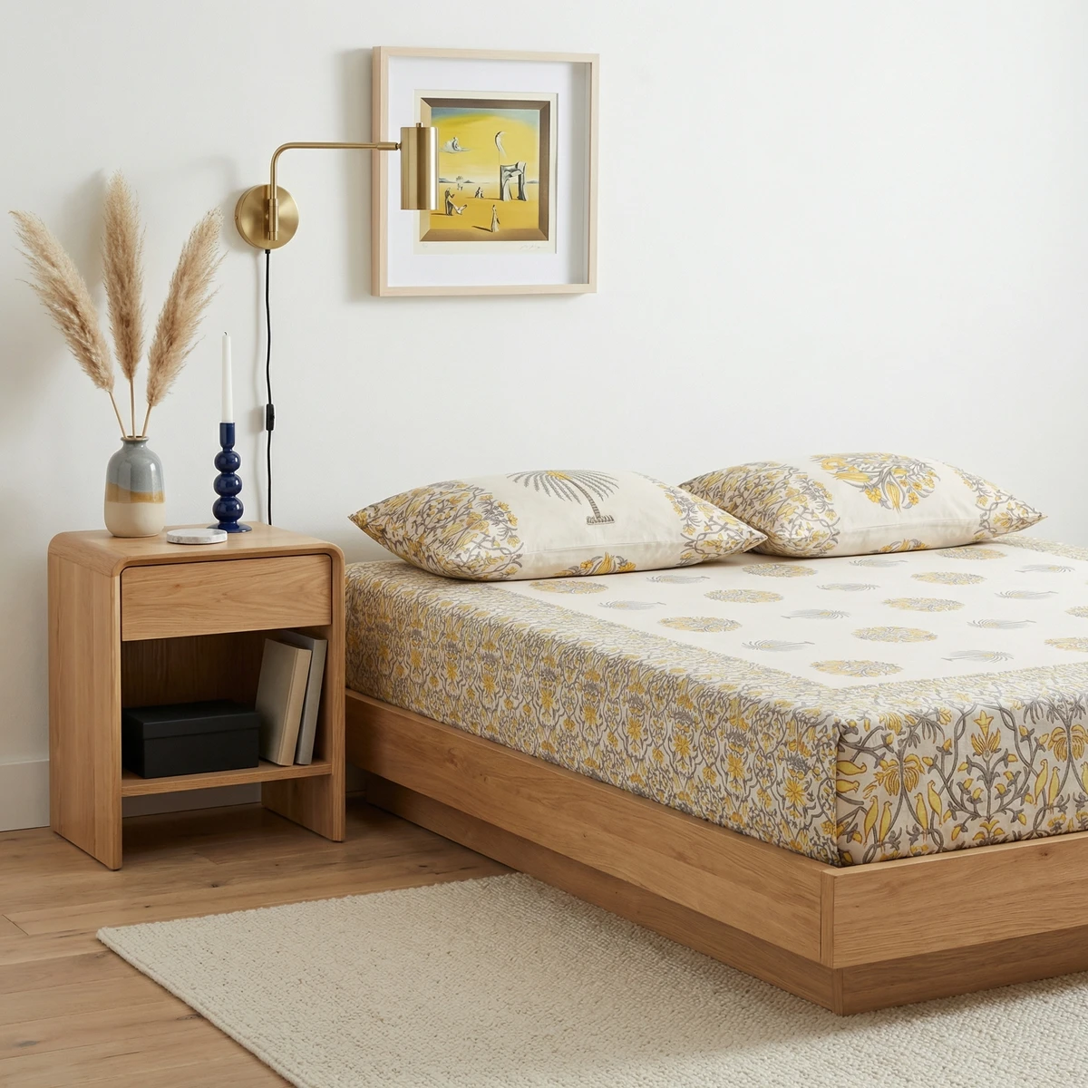 Beige and yellow patterned Kanika bedsheet set on a wooden platform bed with matching pillows.