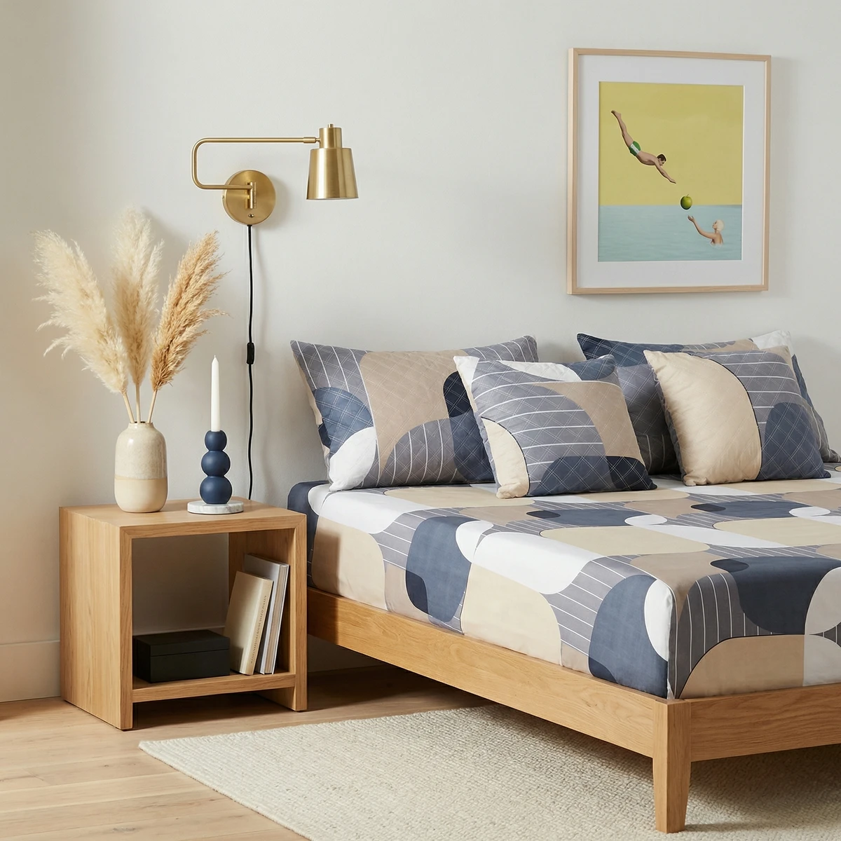 Kanika bed sheets featuring abstract blue, beige, and white geometric shapes in a brightly lit bedroom.